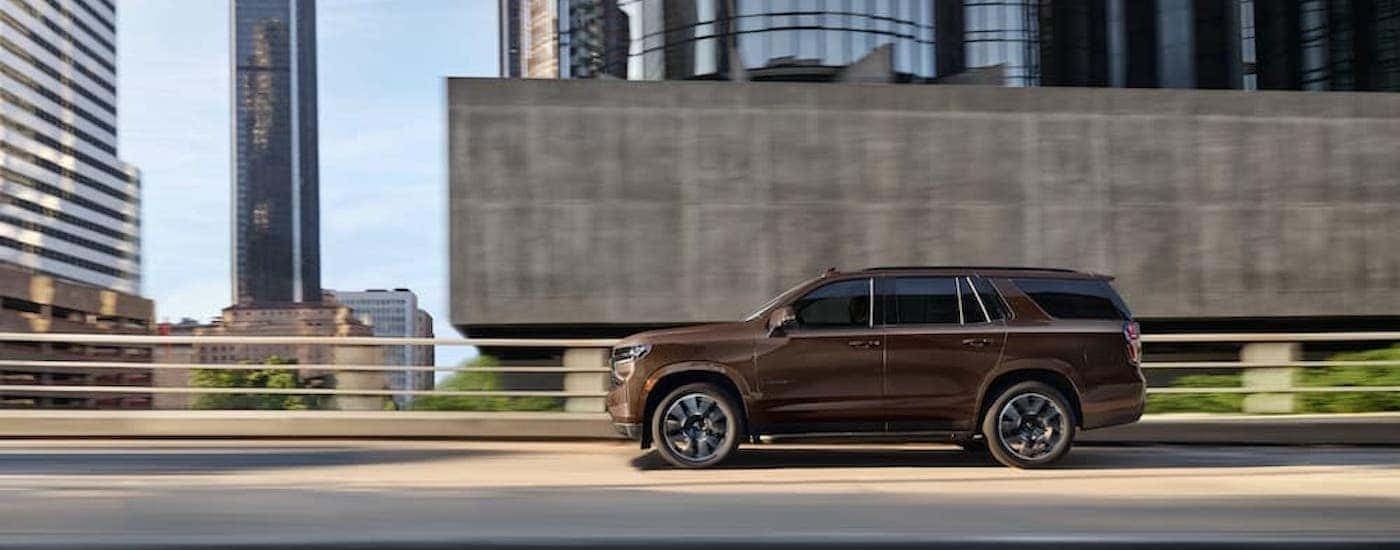 A brown 2022 Chevy Tahoe is shown from the side on the highway.