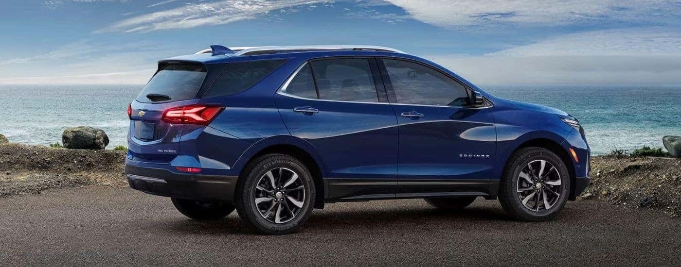 A blue 2023 Chevy Equinox Premier is shown from the side after leaving a dealer that has used cars for sale.