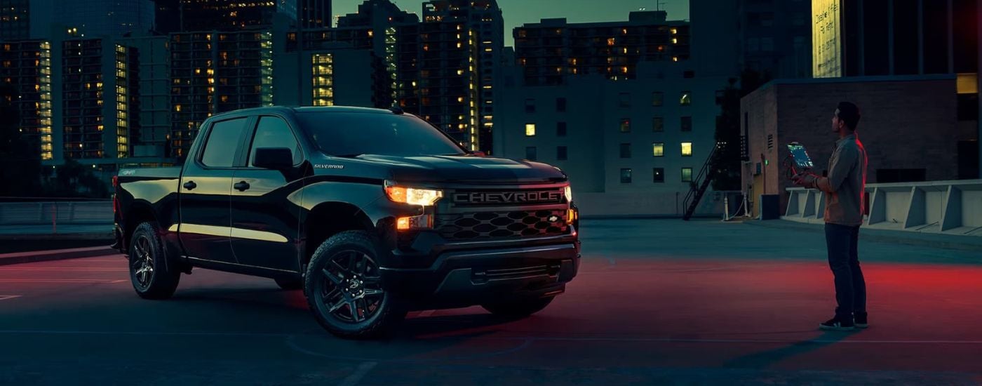 A black 2023 Chevy Silverado 1500 Custom is shown from the front at an angle