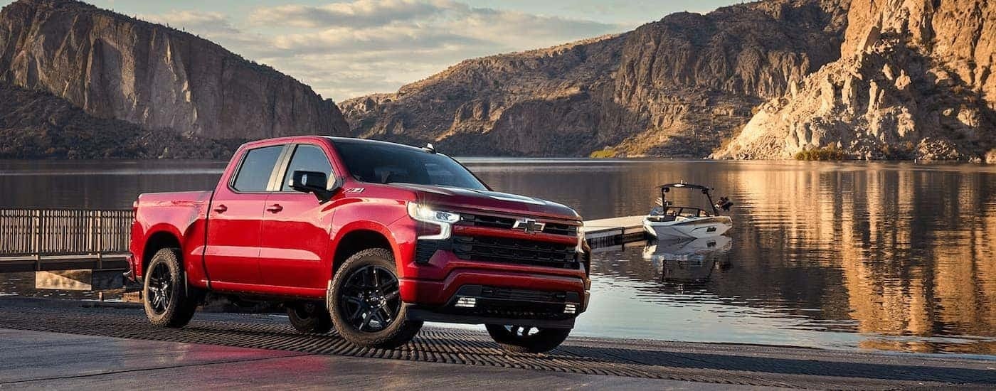A red 2024 Chevy Silverado 1500 LTZ Z71 is parked near a lake.