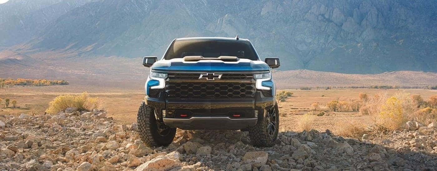 Blue 2024 Chevy Silverado 1500 ZR2 is parked in dirt.