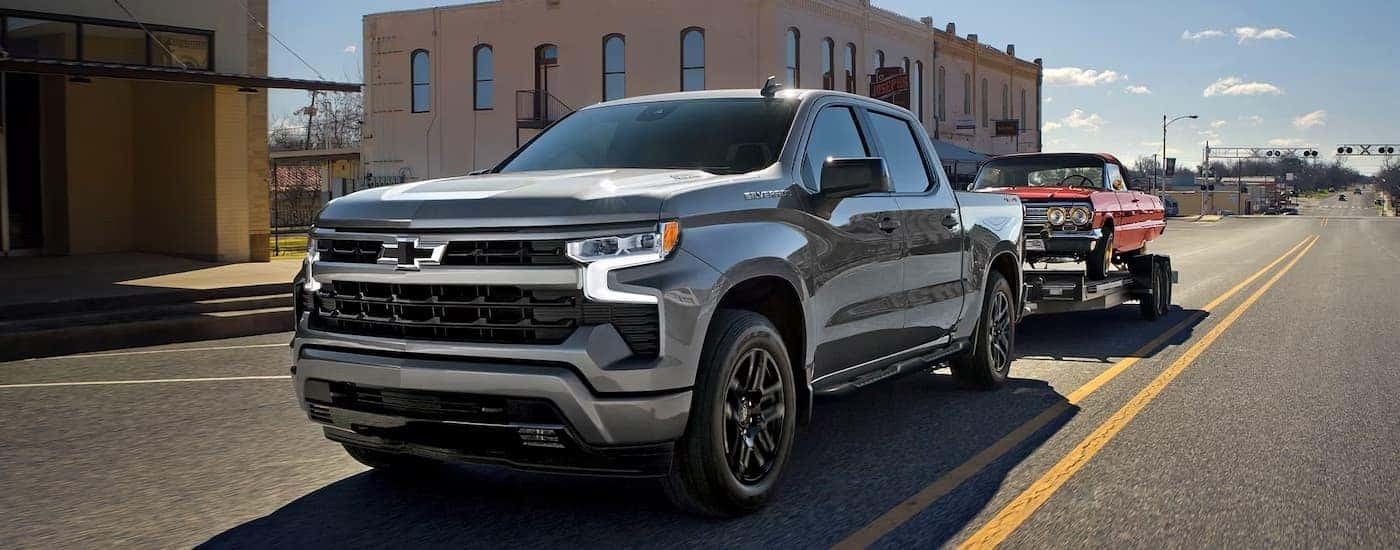 Grey 2026 Chevy Silverado 1500 RST towing a red vehicle