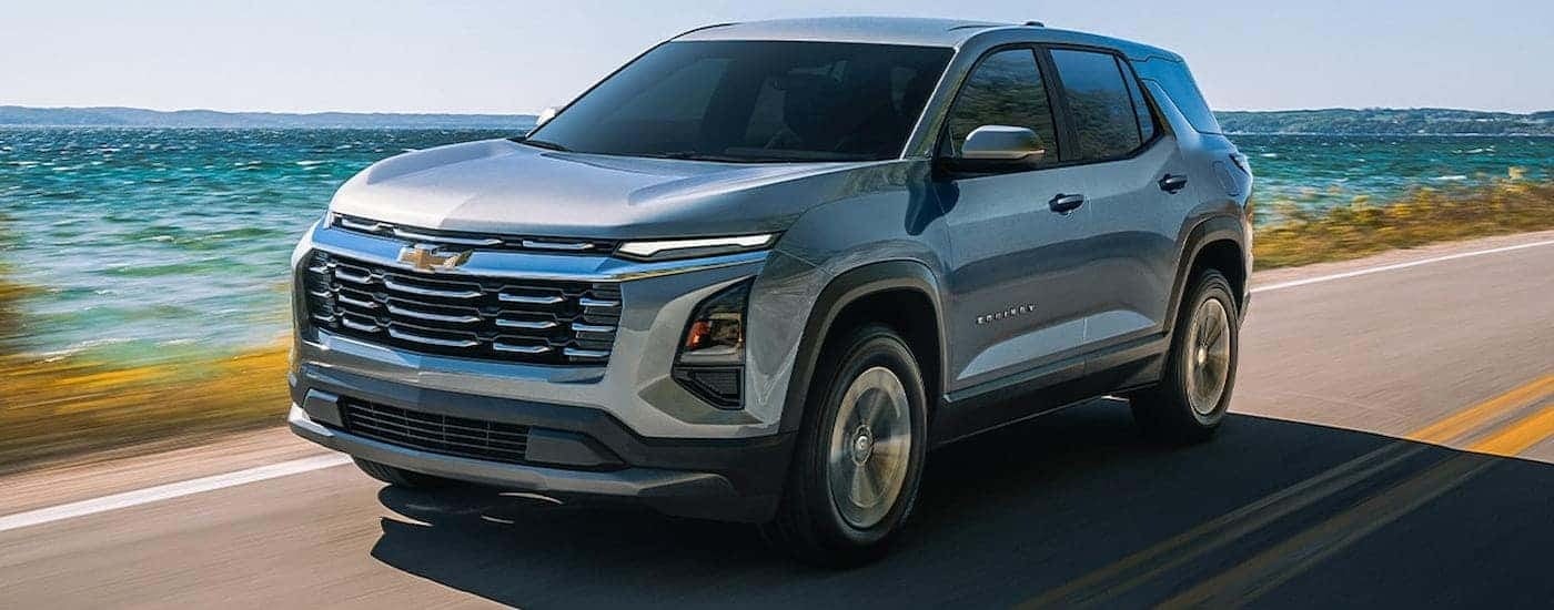 Silver 2026 Chevy Equinox driving down an open road.