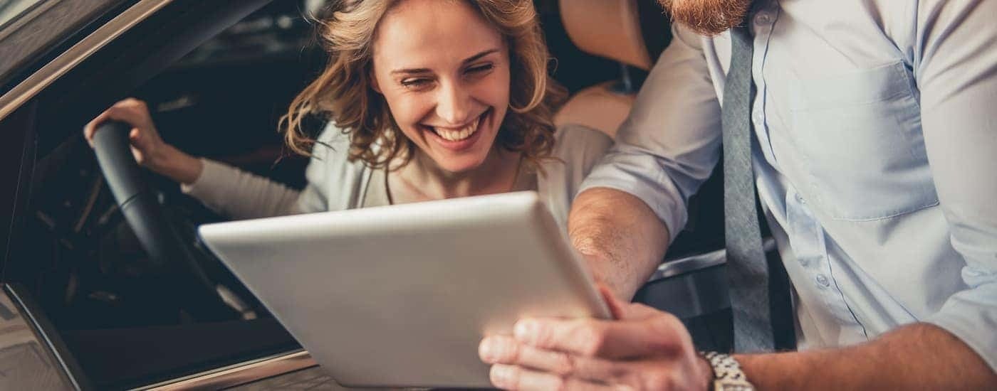 A customer and salesperson are going over financing information on a tablet.