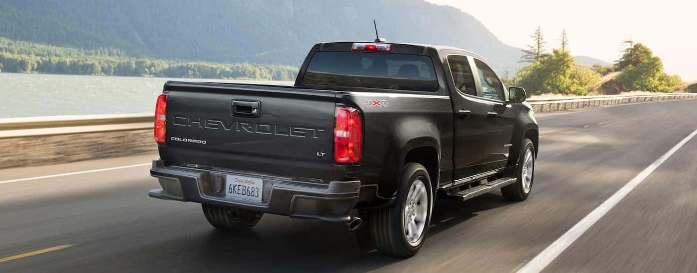 A black 2022 Chevy Colorado LT is shown from a rear angle driving on an open road.