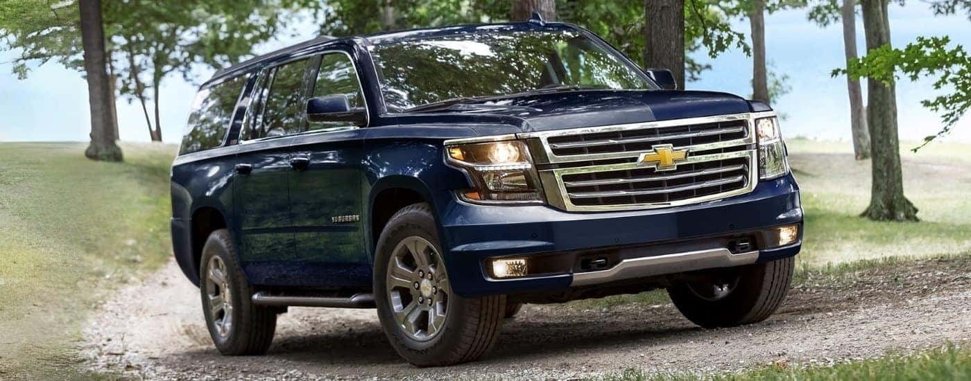 A blue 2019 Chevy Suburban driving on a trail.