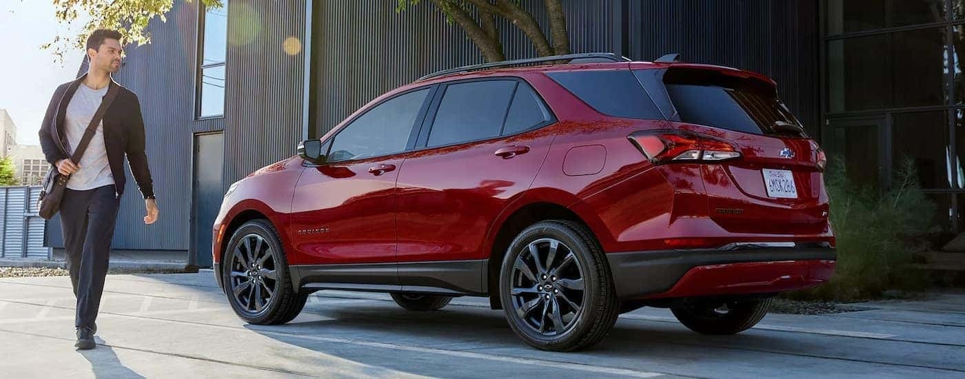 A red 2022 Chevy Equinox RS is shown from the rear on the side of a city street.