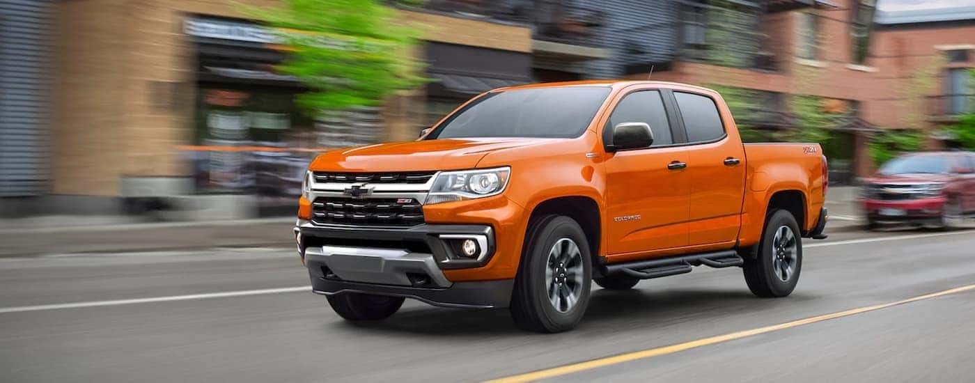 An orange 2021 Chevy Colorado Z71 is shown from the front at an angle.